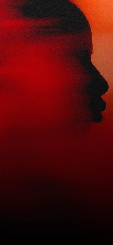 Silhouetted artist profile lit in deep red